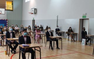Uczniowie w ławkach przed egzaminem
