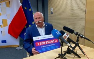 Starosta Chełmski trzymający czek na wsparcie Domów Pomocy Społecznej