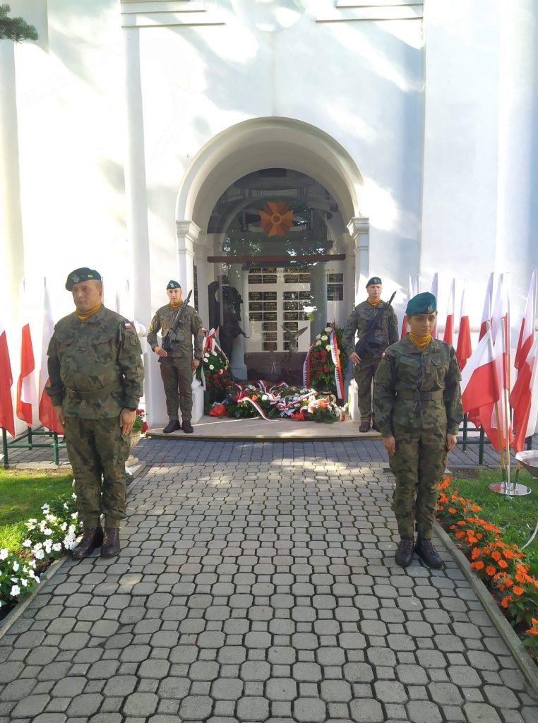 czterech żołnierzy stojących przy pomniku