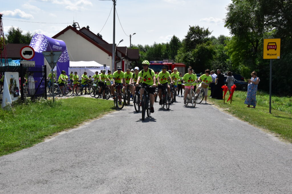 rowerzyści, dmuchana brama w kolorze fioletowym z napisem "z dumą spieramy sport", 