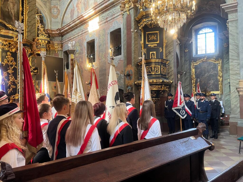 kościół, sztandary, uczniowie, policjanci w mundurach