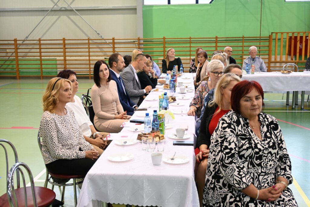 Kilkanaście osób siedzą przy stole.