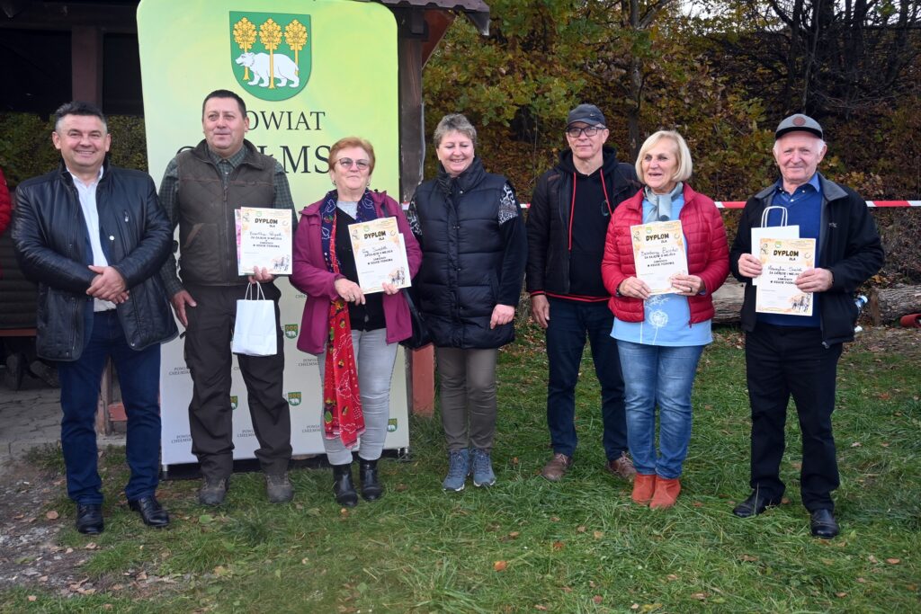 grupa osób stoją, w tle napis Powiat Chełmski