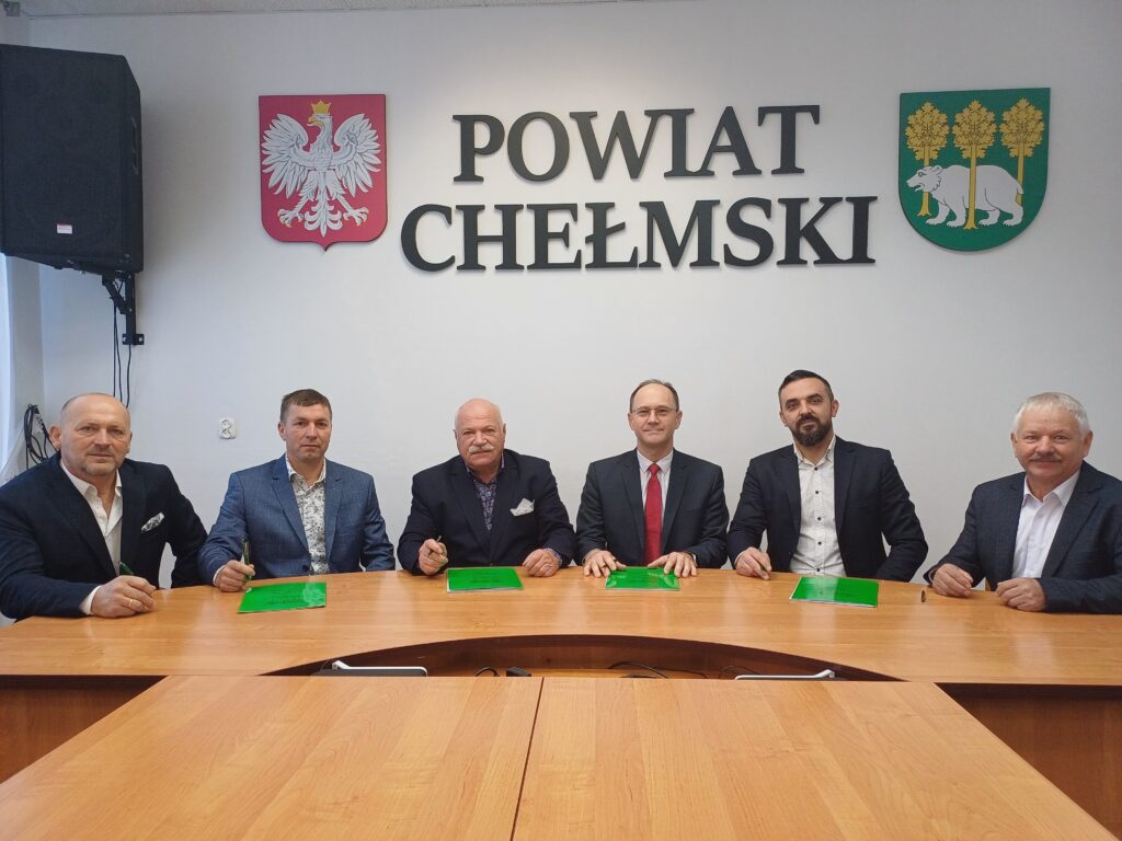 Sześć osób w tle napis: Powiat Chełmski