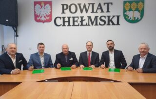 Sześć osób w tle napis: Powiat Chełmski